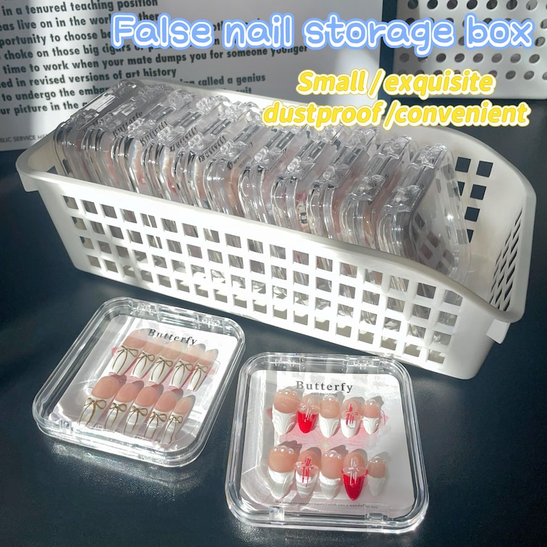 May include: A white plastic storage box filled with clear plastic containers labeled "Butterfly". The containers hold sets of false nails with white and red tips and gold accents. The text "False nail storage box" is written in black on a white background above the box. The text "Small/exquisite dustproof/convenient" is written in black on a white background below the box.