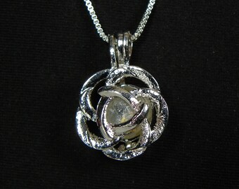 May include: Silver chain necklace with a silver pendant shaped like a rose with a clear crystal in the center.