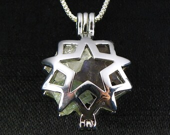 May include: Silver pendant with a star-shaped cage design. The cage holds a clear crystal with a hint of purple.