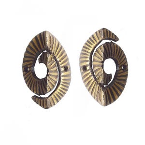 May include: Two oval-shaped brass hardware pieces featuring a textured, spiraling radial pattern. Each piece has a central open void and two small circular mounting holes on the left and right sides, with a dark, aged metallic finish.