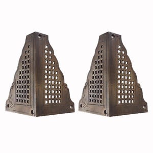 May include: Two antique brass corner brackets with a decorative, geometric, lattice design. The brackets are triangular in shape and have a distressed finish.