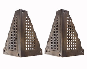 May include: Two antique brass corner brackets with a decorative, geometric, lattice design. The brackets are triangular in shape and have a distressed finish.