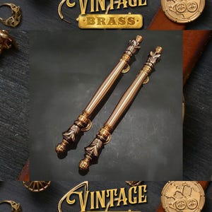 May include: Two ornate gold-toned door handles with intricate designs. The handles are made of brass and have a vintage style.