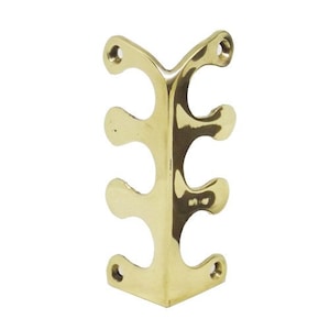 May include: Brass corner bracket with three holes on each side. The bracket is designed to be used in a corner and has a decorative design.