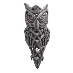 May include: A silver owl pendant with intricate Celtic knotwork design. The owl's eyes are detailed and the pendant has a pointed bottom.