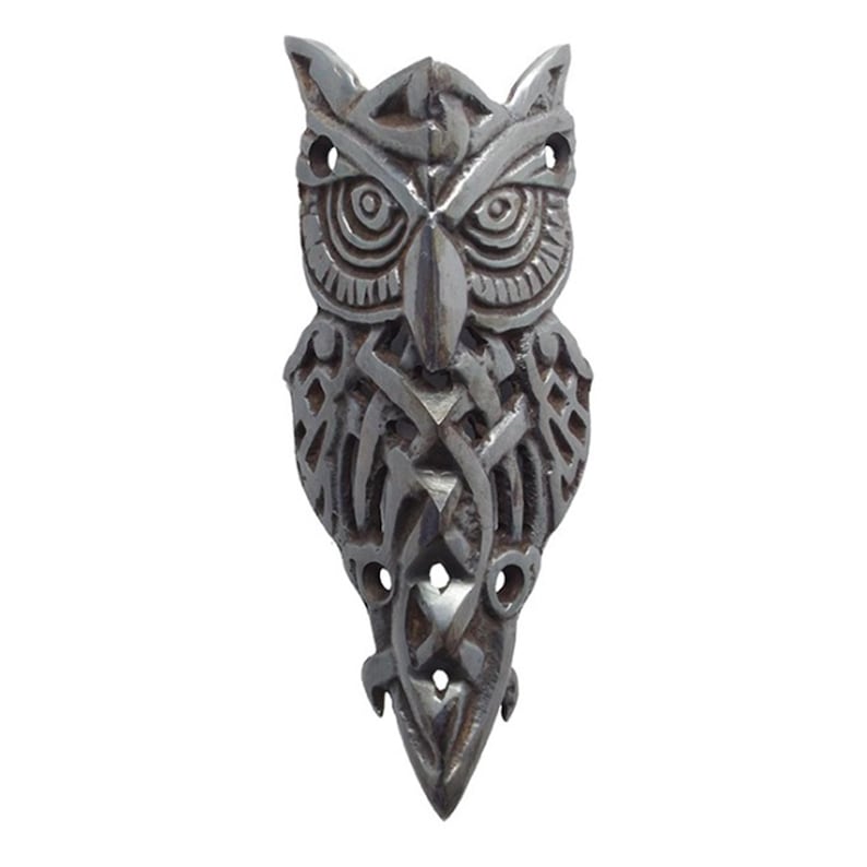May include: A silver owl pendant with intricate Celtic knotwork design. The owl's eyes are detailed and the pendant has a pointed bottom.