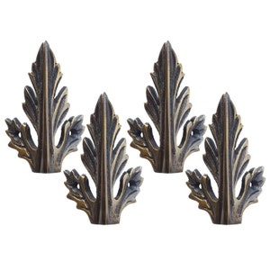 May include: Set of four antique gold leaf-shaped hooks. Each hook is detailed with a raised design and has a pointed tip.