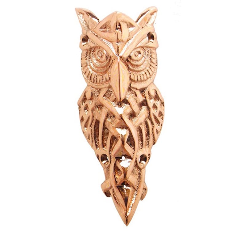 May include: A copper-colored owl pendant with intricate Celtic knotwork design. The owl's eyes are detailed and the pendant is shaped like a long teardrop.