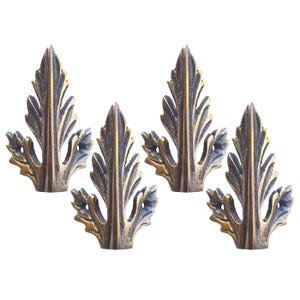 May include: A set of four identical metal corner protectors featuring an ornate, raised leaf-like design with a dark, antiqued bronze finish. Each piece has a pointed top and a textured, layered structure with visible screw holes for mounting.
