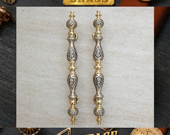 May include: A pair of ornate brass door handles with intricate floral designs. The handles are polished to a high shine and have a vintage look.