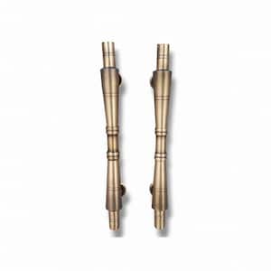 Peut inclure: Deux poignées de porte verticales avec une finition en laiton métallique. Chaque poignée présente un design à fuseau central avec des extrémités effilées et des détails en anneaux horizontaux le long de la tige, offrant un aspect symétrique.