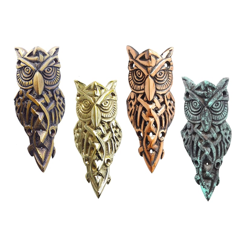 May include: Four owl-shaped corner protector in different finishes: antique, gold, copper, and green. Each owl is intricately detailed with Celtic knotwork.