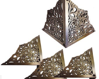 May include: Set of four ornate brass corner brackets with a floral design. The brackets are triangular in shape and have a decorative, intricate pattern.
