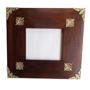 May include: A dark brown wooden picture frame with ornate gold metal corners and accents. The frame has a rectangular opening for a photo or artwork.
