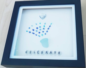 Scottish sea glass celebration picture in boxed frame, suitable for Birthdays, or Anniversaries. Champagne popping from bottle neck.