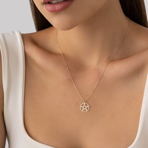 Op de afbeelding: Een gouden ketting met een pentakel hanger. De pentakel is een vijfpuntige ster in een cirkel.