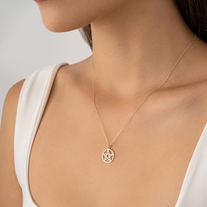Op de afbeelding: Een gouden ketting met een pentacle hanger. De hanger is een vijfpuntige ster in een cirkel.