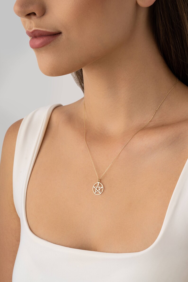Op de afbeelding: Een gouden ketting met een pentacle hanger. De hanger is een vijfpuntige ster in een cirkel.