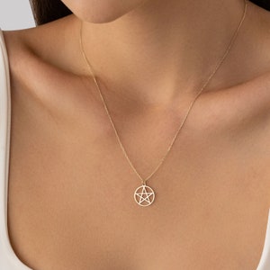 Op de afbeelding: Een gouden ketting met een hanger met een vijfpuntige ster in een cirkel.