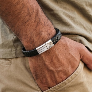 Peut inclure: Bracelet en cuir tressé noir avec fermoir argenté. Le fermoir porte les inscriptions "Love Dad" et "You have that you believe". Un accessoire élégant.