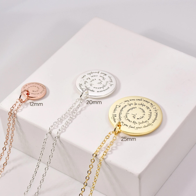 Puede incluir: Tres collares con colgantes en oro rosa, plata y oro. Cada colgante circular tiene una cita inspiradora. El colgante de oro rosa mide 12 mm, el de plata 20 mm y el de oro 25 mm. Cada collar tiene una cadena delicada.