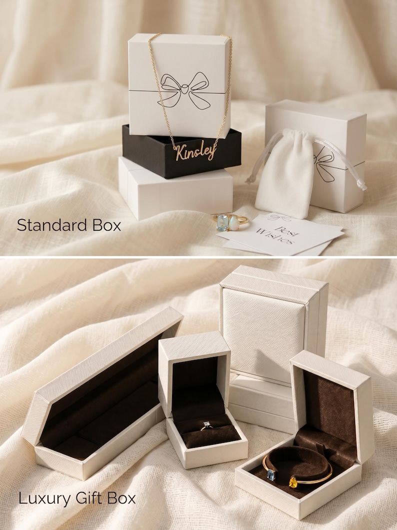 May include: An assortment of jewelry gift boxes in various shapes and sizes. The boxes are white and black, some with a bow design. A gold necklace and rings are visible. The text "Kinsley" is on a black box. The text "Best Wishes" is on a card.