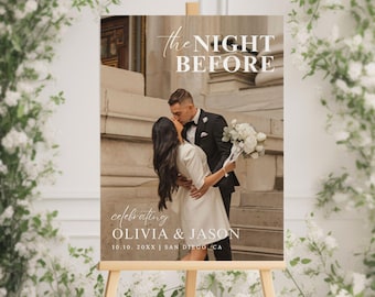 Op de afbeelding: Een welkomstbord voor een bruiloft met een foto van een stel dat voor een gebouw zoent. Het bord staat er: "The Night Before celebrating Olivia & Jason 10.10. 20XX | San Diego, CA"