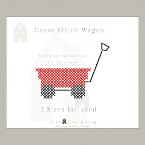 May include: A cross-stitch pattern of a red wagon with black wheels and handle, set against a white background. The text "Cross Stitch Wagon" and "3 Sizes Included" are displayed. The design is from "AT HOME WITH BEAR".