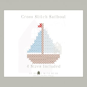 May include: Cross stitch sailboat design with a brown hull, blue and white sails, and a red flag. The text "Cross Stitch Sailboat" and "4 Sizes Included" are displayed. The design is by At Home With Bear.