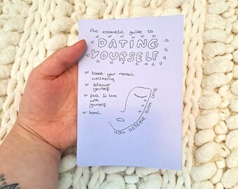 Può includere: Un biglietto viola con il testo "An essential guide to DATING YOURSELF" e un'illustrazione di un viso disegnata a mano con il testo "boost your mental wellbeing, discover yourself, fall in love with yourself, heal, You deserve such love".