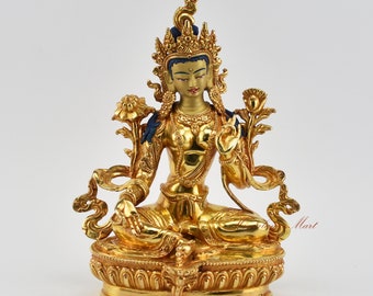 May include: A gold-colored statue of a seated Buddha with a crown and lotus flowers. The statue is made of metal and has a detailed design.