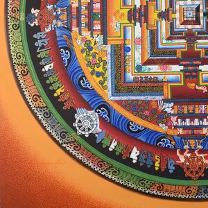 May include: A vibrant, detailed painting of a Buddhist mandala. The artwork features concentric circles with intricate patterns, including geometric shapes, floral motifs, and symbolic imagery. The color palette includes red, blue, yellow, and orange hues.