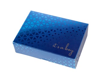 Könnte beinhalten: Eine blaue Geschenkbox mit geometrischem Muster und dem Text "it's a boy" in Gold.