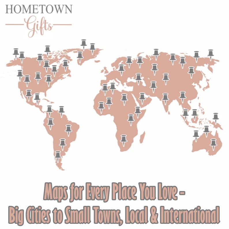 May include: A world map graphic in a muted rose color featuring numerous grey push pins scattered across various continents. The text HOMETOWN Gifts appears at the top, and the text Maps for Every Place You Love - Big Cities to Small Towns, Local & International is at the bottom.