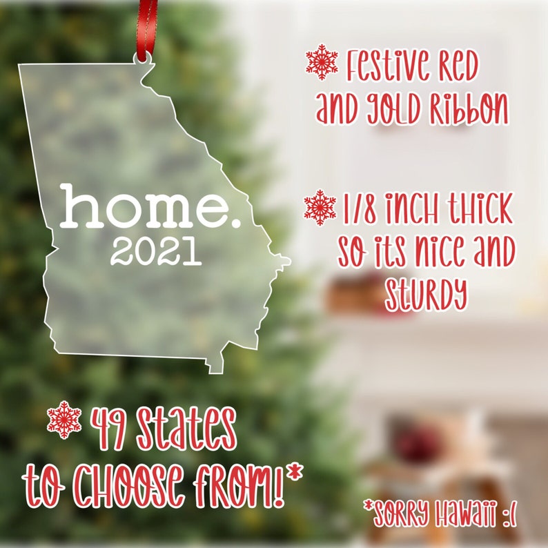 May include: A clear acrylic ornament shaped like the state of Georgia with the word "home" and the year "2021" printed on it. The ornament is decorated with a red ribbon and a snowflake. The text "49 states to choose from!" is printed below the ornament.