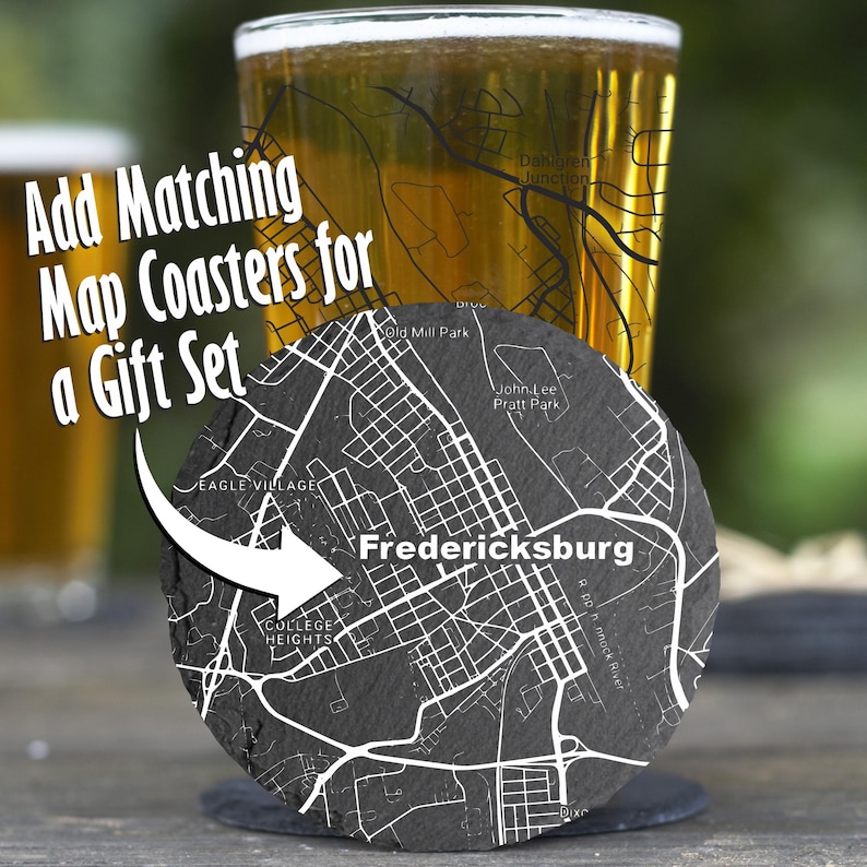 May include: A round, dark gray slate coaster featuring a white engraved street map of Fredericksburg, including labels for Eagle Village and College Heights. The text Add Matching Map Coasters for a Gift Set is overlaid on the image.