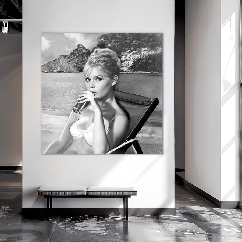 Puede incluir: Impresi&oacute;n art&iacute;stica en blanco y negro de una mujer en bikini bebiendo de un vaso. La imagen est&aacute; ambientada en una playa con monta&ntilde;as y un pueblo costero al fondo. La mujer est&aacute; sentada en una tumbona.