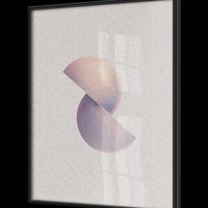 Puede incluir: Impresi&oacute;n art&iacute;stica abstracta con dos formas semicirculares superpuestas en tonos rosa y morado. La obra de arte est&aacute; enmarcada en un marco negro rectangular, creando una est&eacute;tica moderna y minimalista. El fondo es una superficie clara y texturizada.