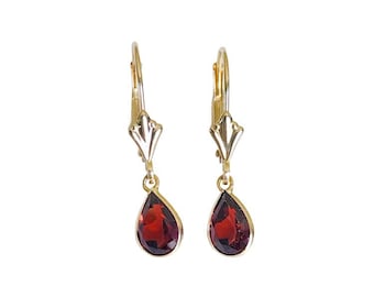 May include: A pair of gold earrings with teardrop-shaped red gemstones.