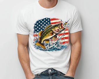 Könnte beinhalten: Ein weißes Kurzarm-T-Shirt mit einem Grafikdruck eines Forellenbarsches, der mit einem Angelköder im Maul aus dem Wasser springt, vor einem Hintergrund aus einer verwitterten amerikanischen Flagge in Rot, Weiß und Blau.