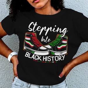 May include: Black t-shirt with the text "Stepping into Black History" and a pair of trainers with red, green and black accents.