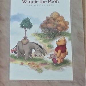 May include: A hardcover book with a dust jacket featuring Winnie the Pooh, Piglet, and Eeyore. The book is titled "Winnie the Pooh One Special Tree" and has 32 pages. The book measures 8.6 inches by 11.2 inches.