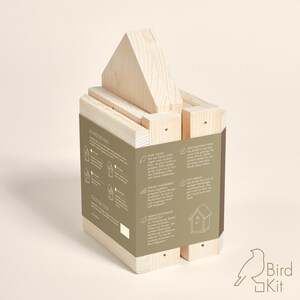 K&ouml;nnte beinhalten: Ein Vogelhaus-Set aus Holz mit Anleitung auf der Seite. Das Set besteht aus Naturholz und ist montagefertig. Das Vogelhaus ist so konzipiert, dass es V&ouml;gel in Ihren Garten lockt.