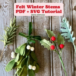 May include: Felt winter stems craft tutorial with PDF and SVG instructions. The image shows five stems with green leaves and red berries, a sprig of green leaves, and a bunch of green leaves with white berries.
