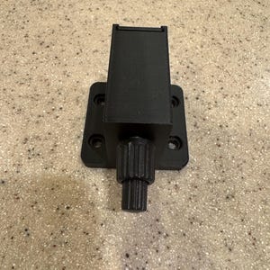 May include: Black metal camera mount with a knob for adjusting the angle. The mount has a rectangular base with four screw holes.