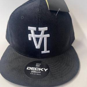 May include: Black corduroy baseball cap with a white "LA" logo embroidered on the front. The cap has a black brim and a black "DECKY Classic Original" label on the side.