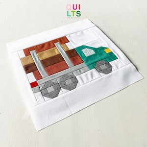 May include: A green and gray truck quilt block with a brown and tan bed. The quilt block is on a white background. The text "QUI LTS AND NICE STUFF" is in the top left corner of the image.