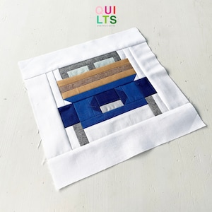 May include: A blue, brown, and white patchwork quilt block with a white border. The block is made up of squares and rectangles of different sizes and colors. The quilt block is a simple design, but it is very effective. The quilt block is perfect for a modern quilt.