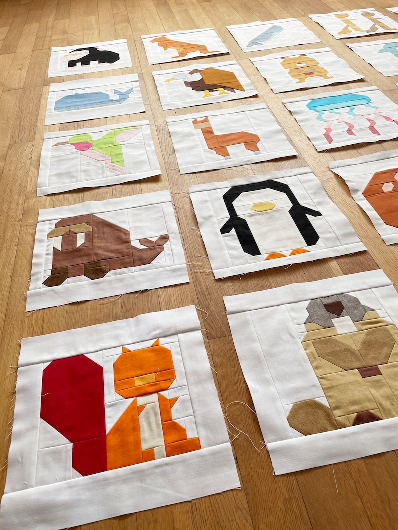 May include: A collection of 16 colourful fabric squares featuring different animal designs. Each square is made of various fabric pieces sewn together to create a pixelated look. The animals include a penguin, a squirrel, a hummingbird, a llama, a whale, a jellyfish, a kangaroo, an eagle, a dog, a turtle, a deer, a fish, and a few others.