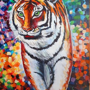 May include: A colorful painting of a tiger walking through a forest. The tiger is painted in shades of orange, white, and black, with green eyes. The background is a vibrant mix of colors, including red, yellow, blue, and green.